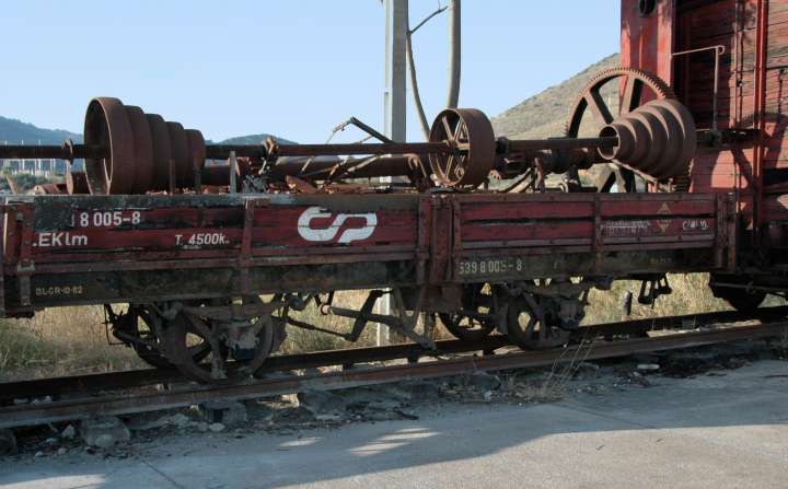 Oldtime four-wheel flatcar with machine-shop load set aside for preservation