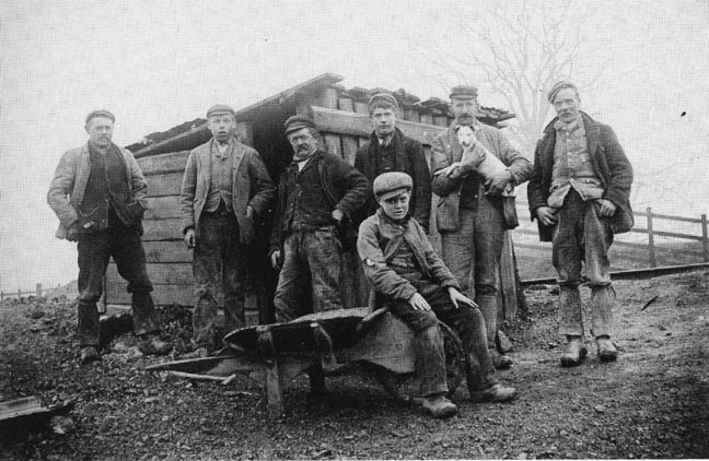 Nipper with navvies outside tommy cabin, 1890s